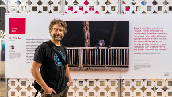 BigPicture 2023 Grand Prize winner Corey Arnold poses with the winning image on exhibit at the Academy